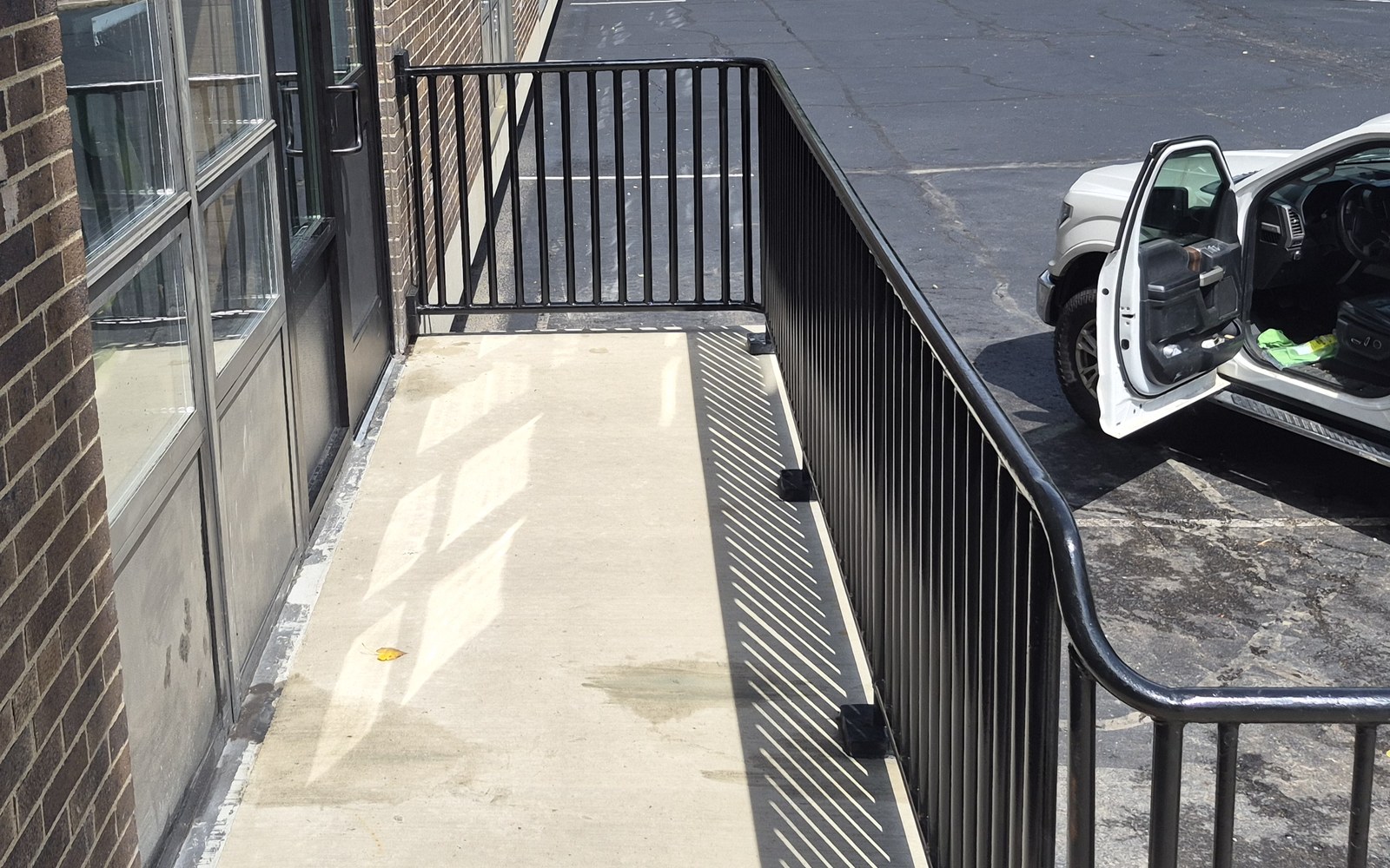 Black steel handrail fabricated and installed by Pro-Line at a commercial building entrance