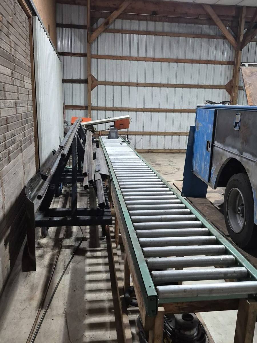 Saw line, roller conveyor and steel stock beside a service body in the Pro-Line shop