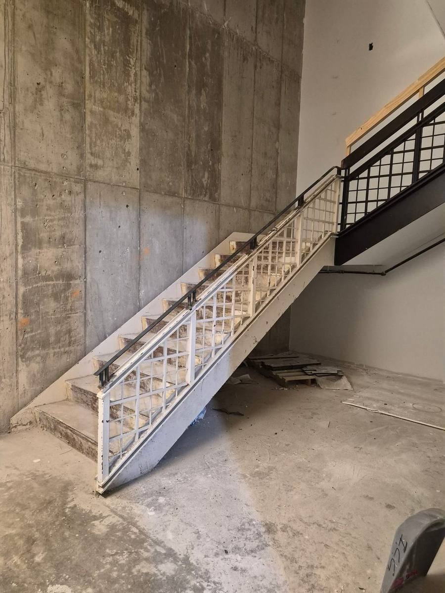 Steel stair rail and mezzanine guardrail fabricated and installed in a commercial stairwell