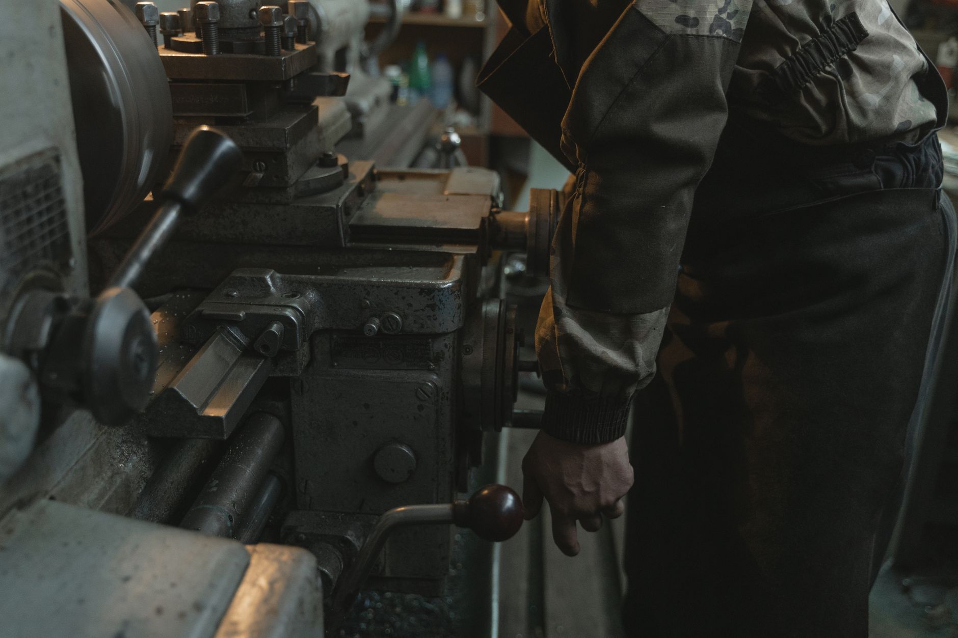 Machinist working at a lathe in an industrial shop